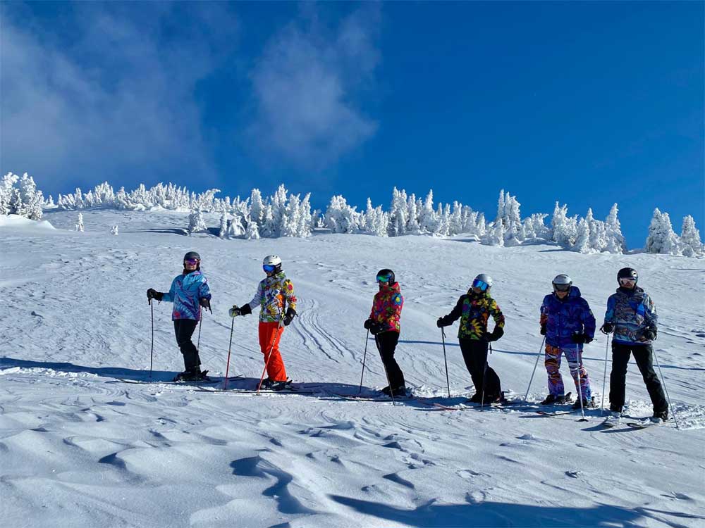 women skiing powder
